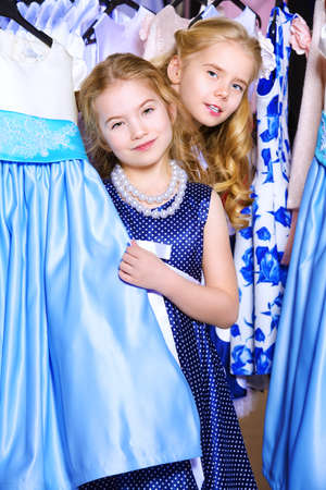 Two cute little girls go shopping. Kid's fashion. Seasonal sale, shopping.の写真素材