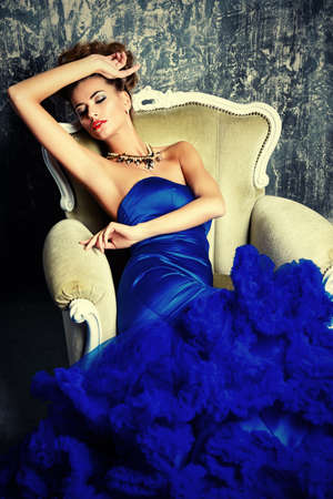 Fashion shot. Beautiful young woman wearing luxurious long dress and necklace. Luxury, rich lifestyle. Jewellery.の写真素材