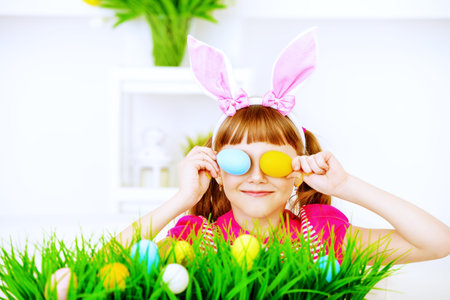 Funny happy girl wearing bunny ears celebrating Easter at home.