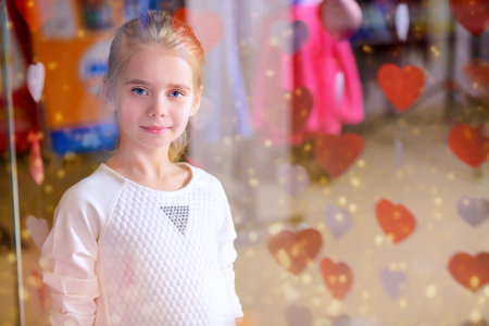 Cute little girl looking at the shop window. Seasonal sale, shopping. Kid's fashion. Modern...
