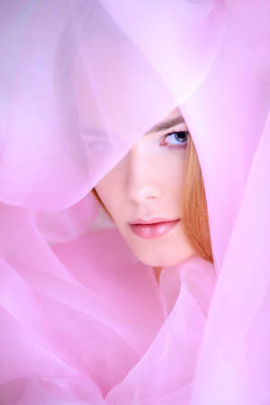 Portrait of a beautiful gentle girl in a light cloak of organza. The image of purity and innocence. Bodycare, skincare, natural cosmetics.の写真素材