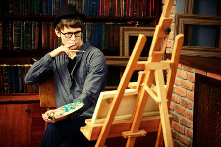 Inspired artist man draws a picture in the workshop. Arts and painting.の写真素材