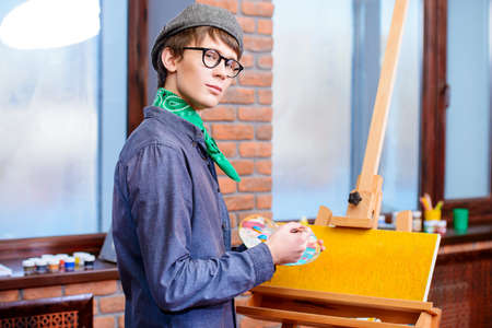 Inspired artist man draws a picture in the workshop. Arts and painting.の写真素材