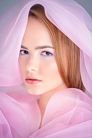 Portrait of a beautiful gentle girl in a light cloak of organza. The image of purity and innocence. Bodycare, skincare, natural cosmetics.の写真素材