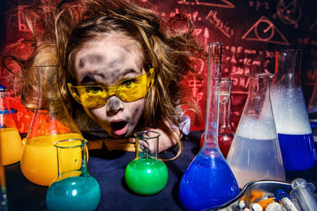 Funny little girl doing experiments in the laboratory. Explosion in the laboratory. Science and education.の写真素材