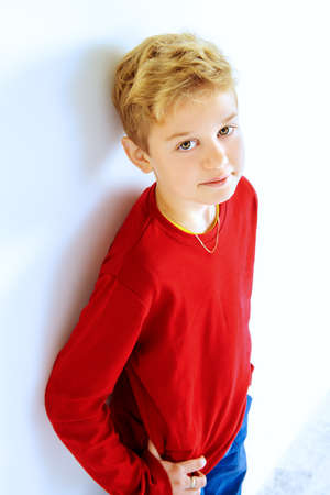 Cute nine-year boy leaning against the wall. Children's fashion. Education.の写真素材
