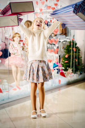 Happy little girl goes shopping. Kid's fashion. Modern children. Seasonal sale, shopping.の写真素材