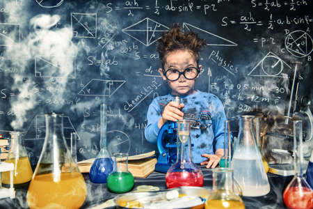 Little boy doing experiments in the laboratory. Explosion in the laboratory. Science and education.の写真素材