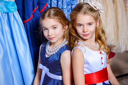 Two little fashionable girls go shopping. Kid's fashion. Seasonal sale, shopping.の写真素材