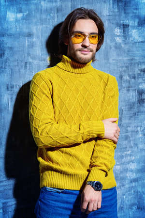 Handsome man wearing yellow pullover and sunglasses. Men's beauty, fashion. Hairstyle for men.の写真素材