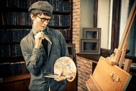 Inspired artist man draws a picture in the workshop. Arts and painting.の写真素材