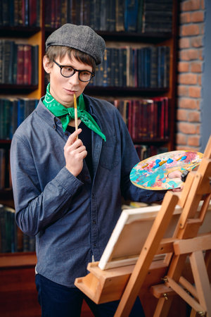 Inspired artist man draws a picture in the workshop. Arts and painting.の写真素材