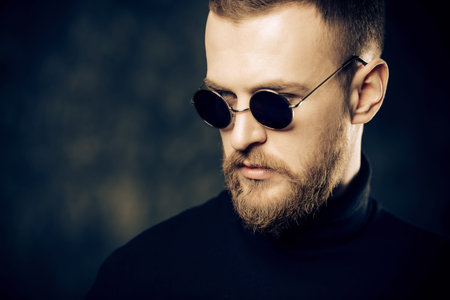 Handsome bearded man wearing round sunglasses. Male fashion.