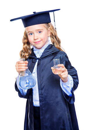 Portrait of a cute nine year old girl in an academic gown and hat holding beakers. Educational concept. Isolated over white.の写真素材