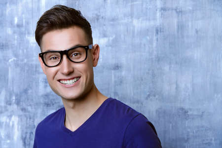 Portrait of a positive smiling young man in glasses. Studio shot.の写真素材