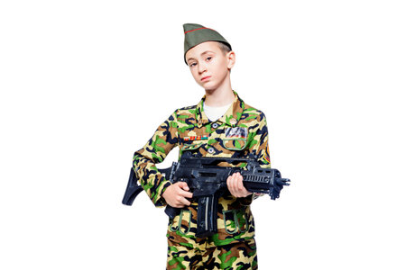 Different professions. A boy  dressed in military costume holding a gun. Soldier. Isolated over...