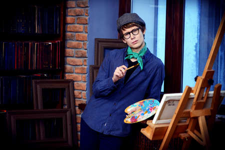 Inspired artist man draws a picture in the workshop. Arts and painting.の写真素材