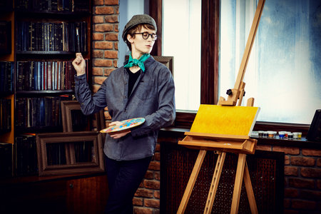 Inspired artist man draws a picture in the workshop. Arts and painting.