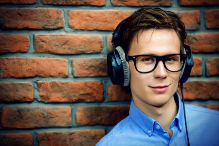 Happy young man listens to music in headphones at home. Radio music, DJ.の写真素材
