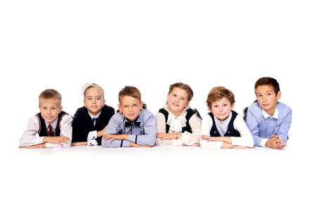 Group of happy school children posing together at studio. School uniform. Educational concept. Isolated over white.の写真素材