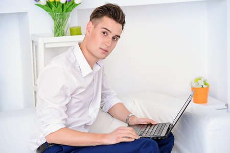 Young man in white shirt working on a laptop. Business concept.の写真素材