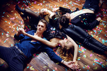 Group of cheerful young people relaxing after night party.の写真素材