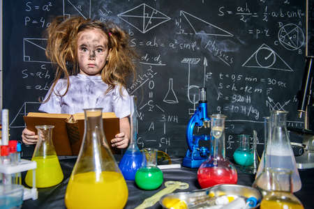 Funny little girl doing experiments in the laboratory. Explosion in the laboratory. Science and education.の写真素材
