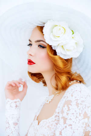 Portrait of a beautiful tender bride woman wearing elegant lace dress and broad-brimmed hat.の写真素材