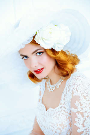 Portrait of a beautiful tender bride woman wearing elegant lace dress and broad-brimmed hat.の写真素材