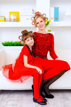 Happy mother with her lovely daughter preparing for the holiday, doing hairstyles and makeup. Happy family concept. Beauty, fashion.の写真素材