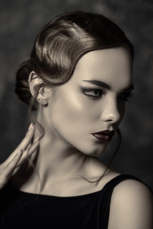 Portrait of a beautiful charming woman with old fashioned make-up and finger wave hairstyle. ...