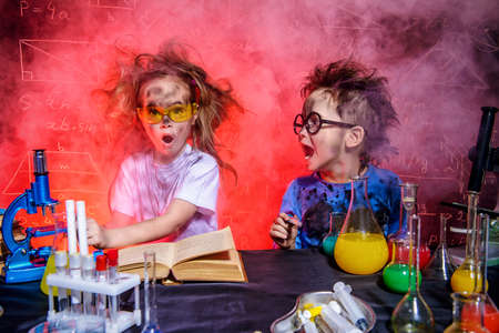 Funny little children doing experiments in the laboratory. Explosion in the laboratory. Science and education.の写真素材