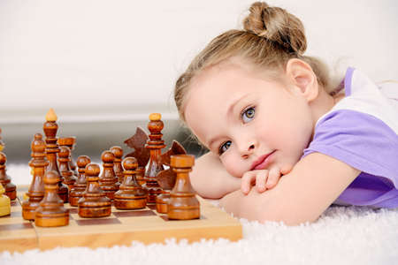 Little girl playing chess at home. Games and activities for children. Family concept.の写真素材