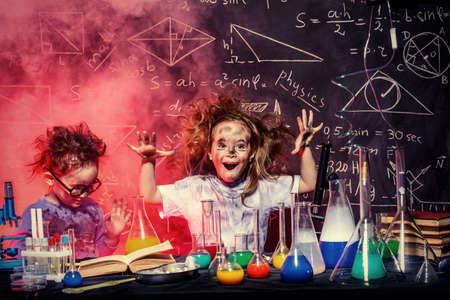 Funny little children doing experiments in the laboratory. Explosion in the laboratory. Science and education.の写真素材