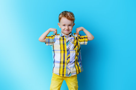Portrait of a cute laughing little boy. Blue background.