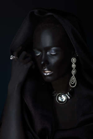 Fashion jewellery concept. Portrait of a beautiful young woman with perfect black skin and Diamond jewelry. Body painting project.の写真素材