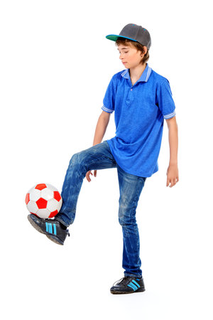 Studio portrait of a boy teenager with football. Isolated over white background.の写真素材