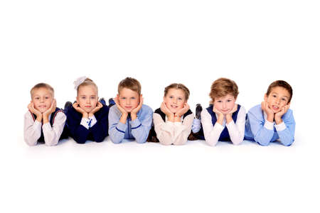 Group of happy school children posing together at studio. School uniform. Educational concept. Isolated over white.の写真素材