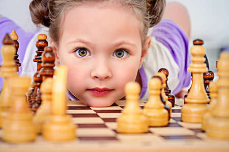 Little girl playing chess at home. Games and activities for children. Family concept.の写真素材