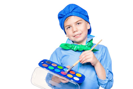 Cute boy dressed in a costume of an artist holds brush and paints. Isolated over white.の写真素材