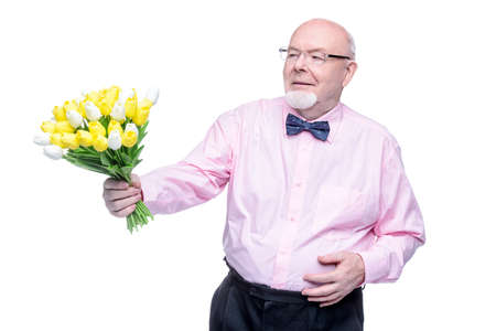 Happy smiling old man gives a bouquet of tulips flowers. Women's Day, 8 of March, birthday concept. Retirement. Isolated over white.の写真素材