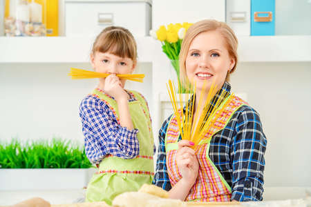 Loving family concept. Happy mother cooks with her daughter.の写真素材