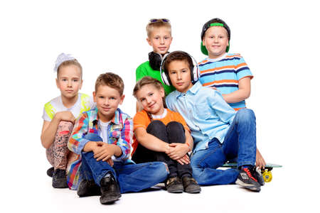 Group of happy children posing together at studio. Kid's fashion. Education. Isolated over white.の写真素材