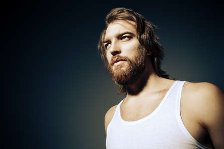 Close-up portrait of a brutal bearded man wearing white t-shirt.の写真素材