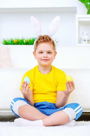Easter holidays. Funny happy boy wearing bunny ears celebrating Easter at home.