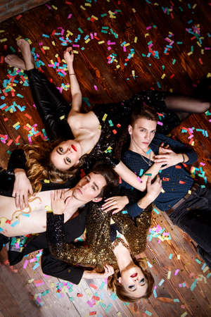 After party. Group of cheerful young people relaxing after night party.の写真素材