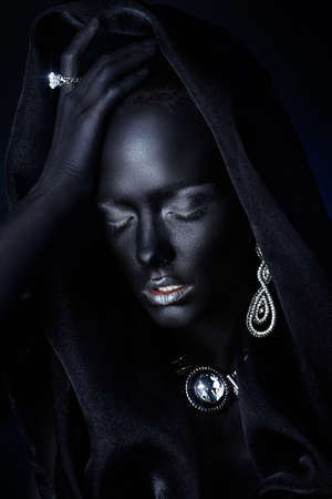 Fashion jewellery concept. Portrait of a beautiful young woman with perfect black skin and Diamond jewelry. Body painting project.の写真素材