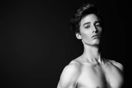 Black-and-white portrait of a sexy muscular young man over black background.の写真素材