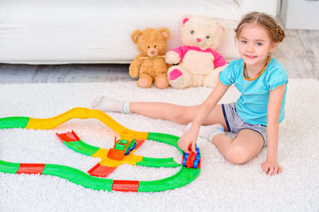 Happy smiling girl playing with railway at home. Family concept.の写真素材