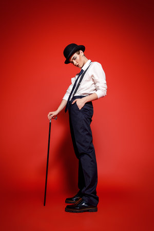 Fashion shot. Attractive young model posing in a man's suit and bowler hat. Man's style clothing....